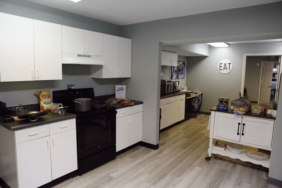 The Hope Center kitchen with white cabinets and a round EAT sign on the wall.